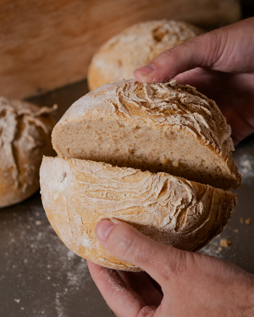 Manos sosteniendo panes sin gluten recién horneados
